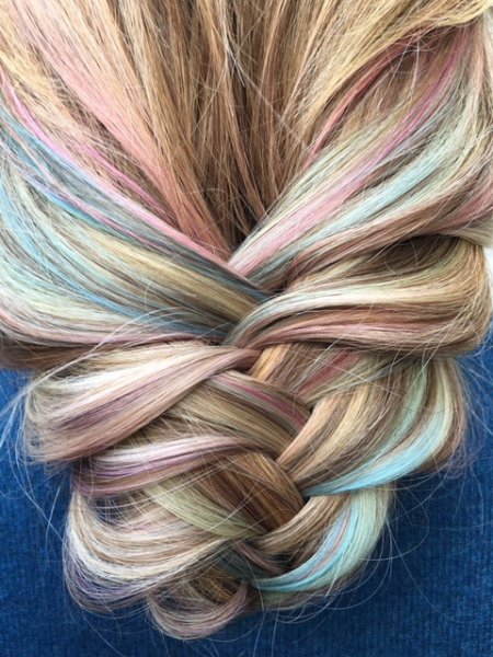 Soft pastel tones running through a loosely plaited hair giving textured finish at the klinik hairdressing Islington