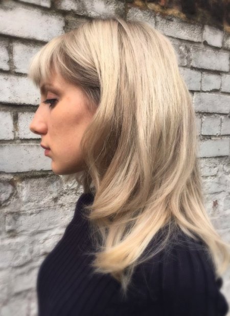 Blonde hair being multitoned by introducing more softe beige colours to create a reverse balayage at the klinik.