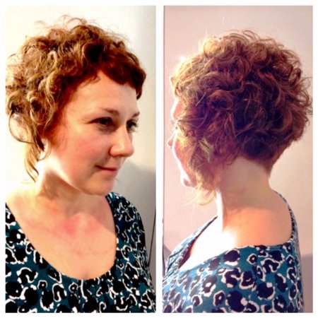 curly hair being cut with a sharp short graduation and wit a lot of texture to bring out the curls