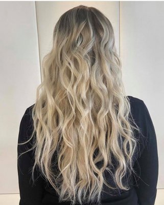 Long blonde hair styled with a mermaid wave by Leyla at the klinik salon London