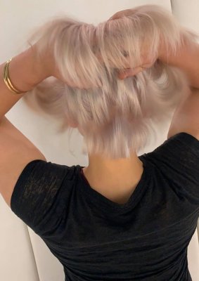 girl running her fingers through her newly coloured blonde hair at the klinik hairdressing in London