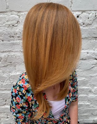 Long strawberry blonde hair on a lady in a floral dress at the klinik hairdressing London