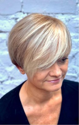 girl sitting on a bench with a blonde fringe and darkblond all over colour on the rest of her hair at the klinik salon London
