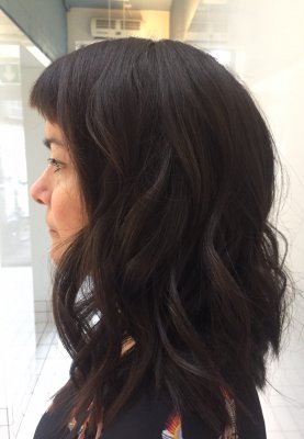 Thick hair being cut into a long shoulder length with a soft graduation at the back at the klinik hairslon London