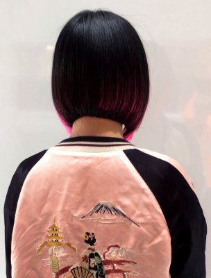 Thick dark hair has been cut into a bob to expose the already there pink bits on the sides done by Mark at the klinik hairdressing London.