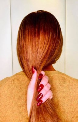 Copper hair with a hand with red nails running through it at the klinik salon London