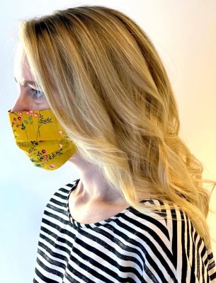 Lady with golden balayage wearing a white and navy top with a yellow face mask at the klinik salon London