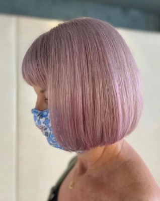 lady with blue face mask having a lavender tone on her hair colour done by Leyla at the klinik salon London